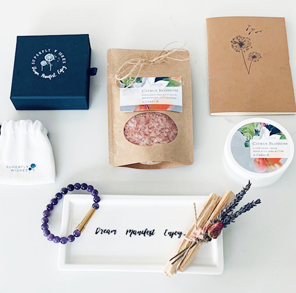 manifestation gift set filled with a semi-precious crystal bracelet to set intensions, himalayan citrus bath salts, citrus handcream, sleep journal, naturally sourced palo santo bundle, and a ceramic bedside tray